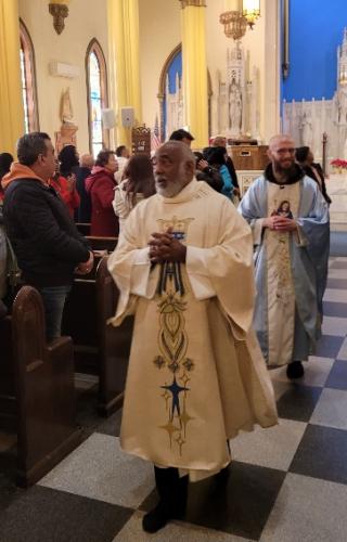 Deacon Osvaldo and Fr Francis waving parishioners